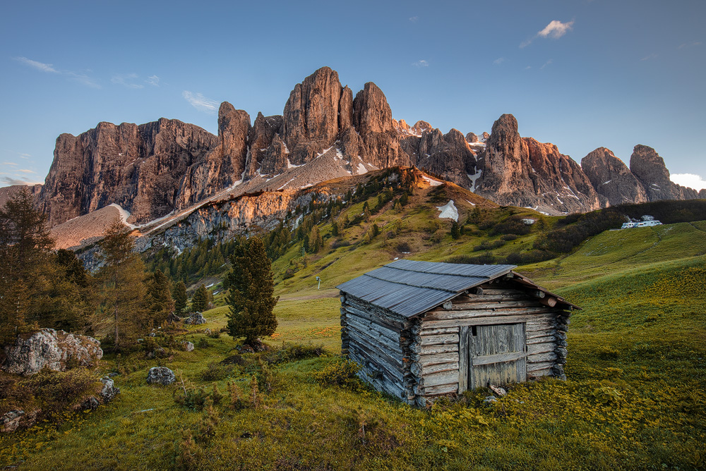 Alter Stadl am Grödner Joch vor den von der untergehenden Sonne noch beleuchteten Felswände des Sellastockes